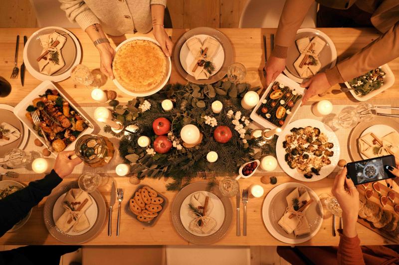 People pass holiday meal items around the table
